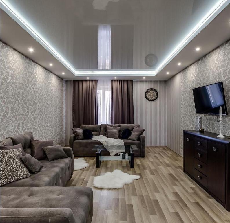 uma sala de estar com dois sofás e uma televisão em Viktoria Garden apartment em Lviv