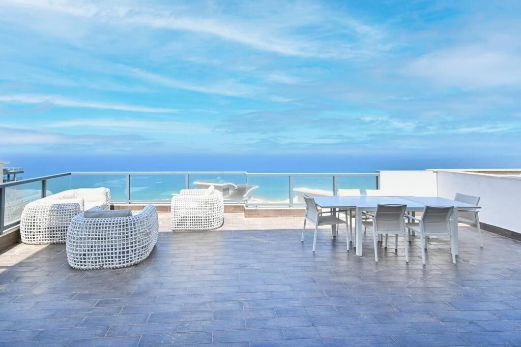 a table and chairs on a balcony with the ocean at Luxury Penthouse in Netanya in Netanya