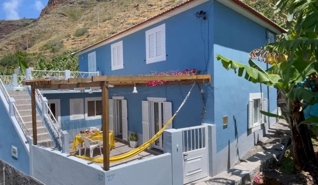 uma casa azul com uma mangueira amarela em Blue by the Sea House em Paul do Mar