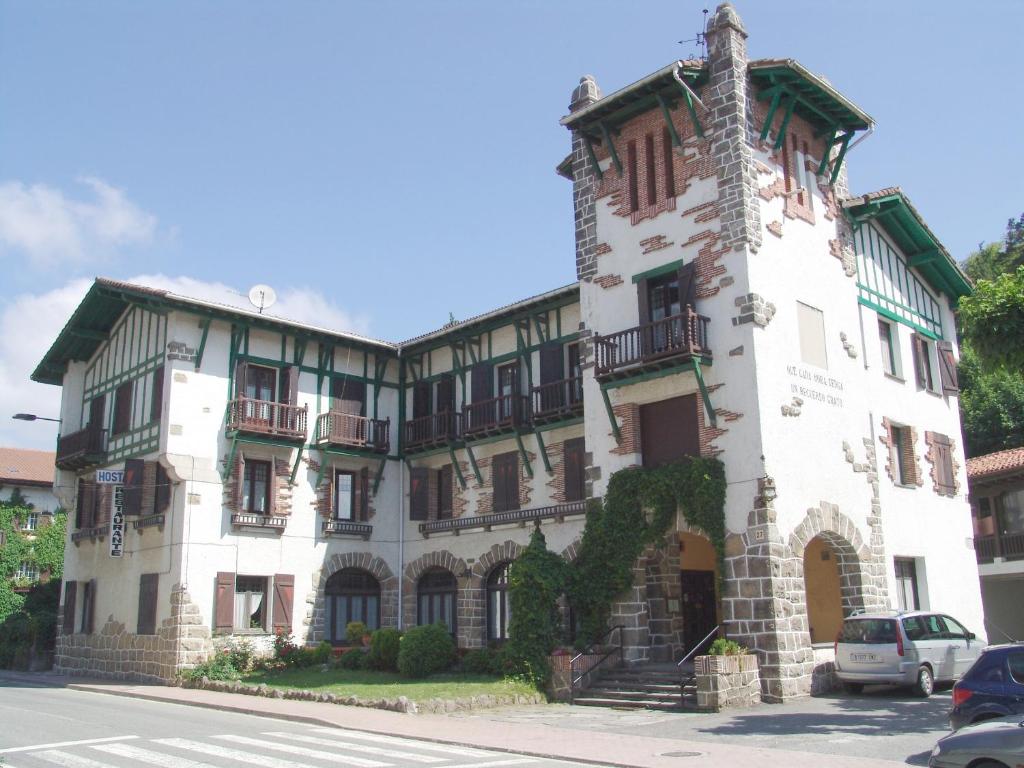 un gran edificio blanco con una torre en Hostal Ayestaran II en Lekunberri