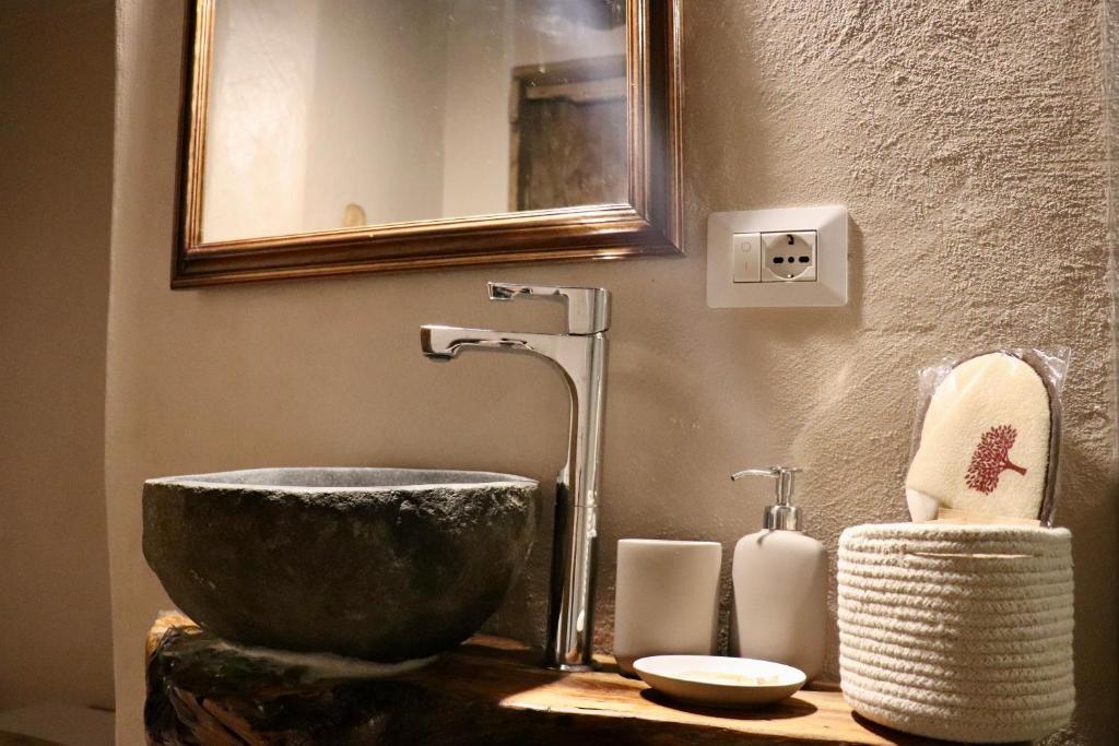 a bathroom with a bowl sink and a mirror at La casa del Teatro in Campiglia dʼOrcia