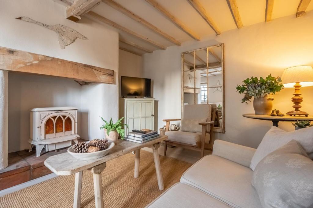 a living room with a couch and a fireplace at The Beekeepers Cottage in Barney