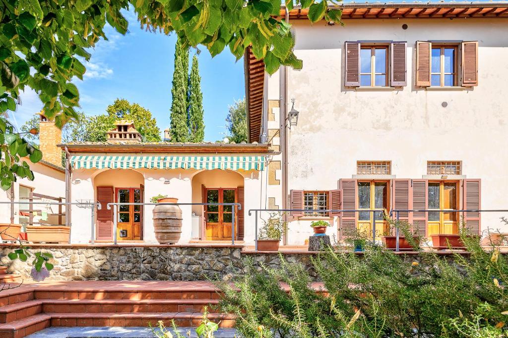 una casa con una escalera delante de ella en Casale - I Tre Cipressi, en Arezzo