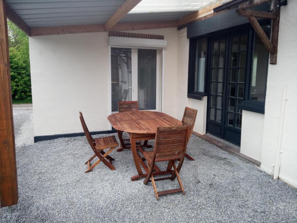 a wooden table and chairs on a patio at LE CHANT DES OISEAUX arrivée autonome in Sorbais