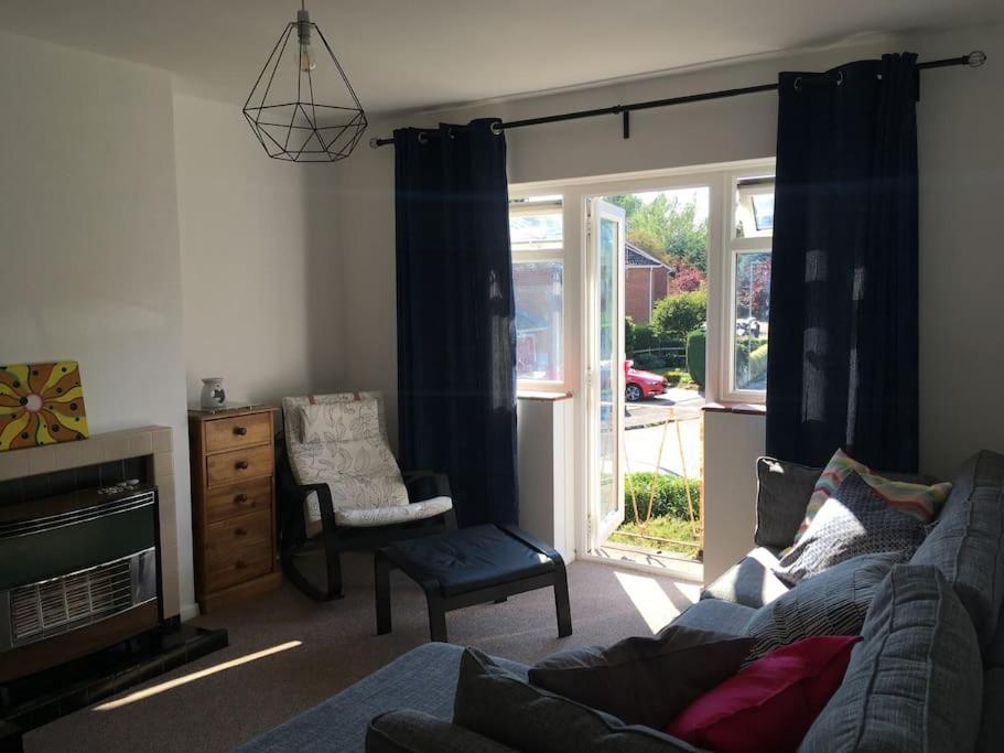uma sala de estar com um sofá e uma cadeira em Entire 2 bed apartment - Up to 4 guest - 10 min from station and town centre em Wokingham
