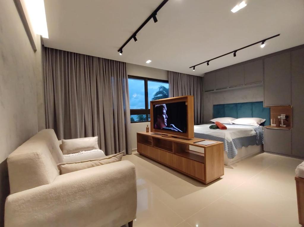 1 dormitorio con 1 cama, TV y sofá en Rio Park Ave, Studio 9 - By TRH Invest, en Recife
