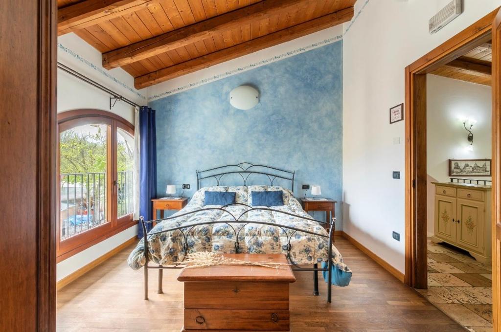 a bedroom with a bed with a blue wall at Agriturismo Porcaloca in Casale sul Sile