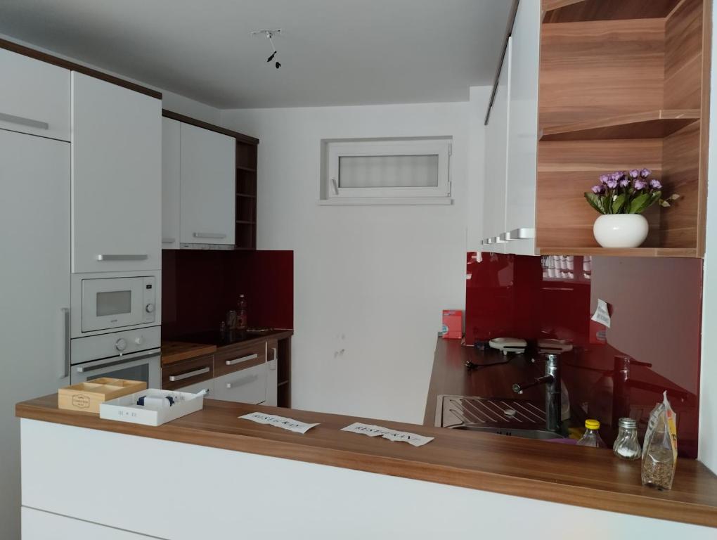 a kitchen with white cabinets and a wooden counter top at Residence Mahala in Sarajevo