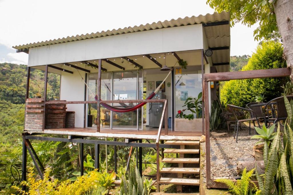 une petite maison avec un hamac en face de celle-ci dans l'établissement Cabaña Tierra Verde eje Cafetero, à Manizales