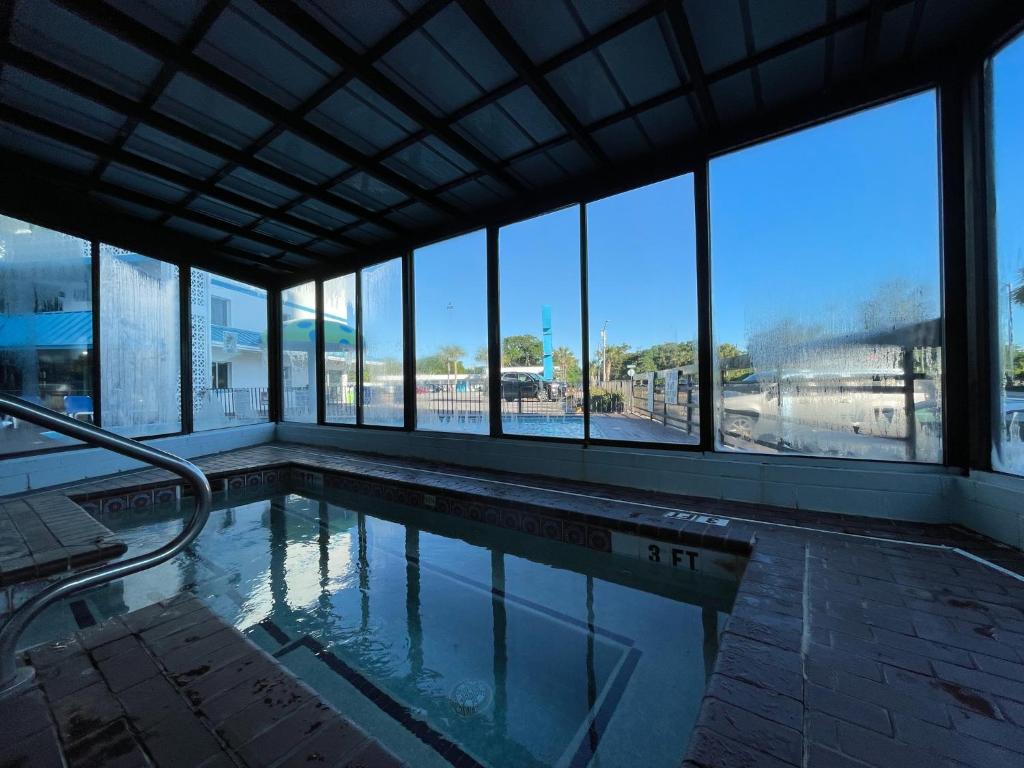 einen Pool in einem Gebäude mit Glasfenstern in der Unterkunft Polynesian Oceanfront Hotel in Myrtle Beach