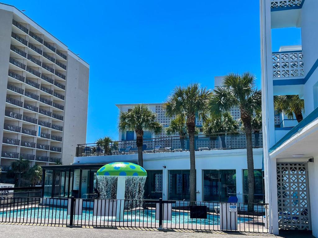 ein Gebäude mit Palmen und einem Regenschirm in der Unterkunft Polynesian Oceanfront Hotel in Myrtle Beach