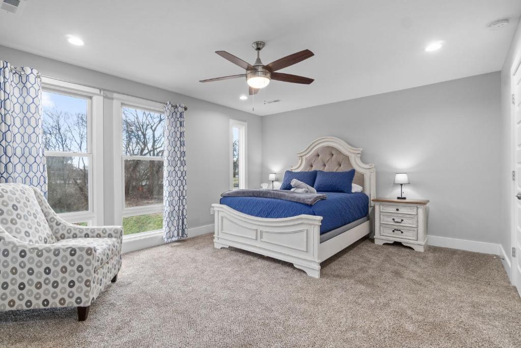a bedroom with a bed and a chair and a ceiling fan at Upscale Downtown Condo W Outdoor Patio And Parking in Clarksville