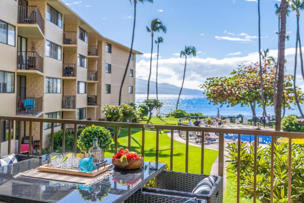 a balcony with a table and a view of the ocean at Kanai A Nalu 211 in Wailuku