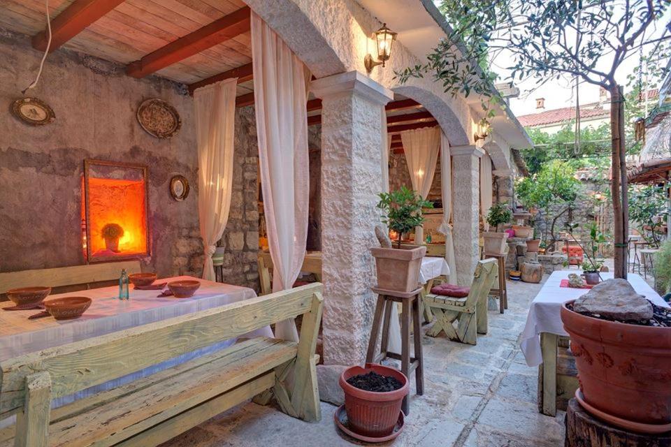 an outdoor patio with tables and chairs and a fireplace at Best Location Old Town Budva Rooms in Budva