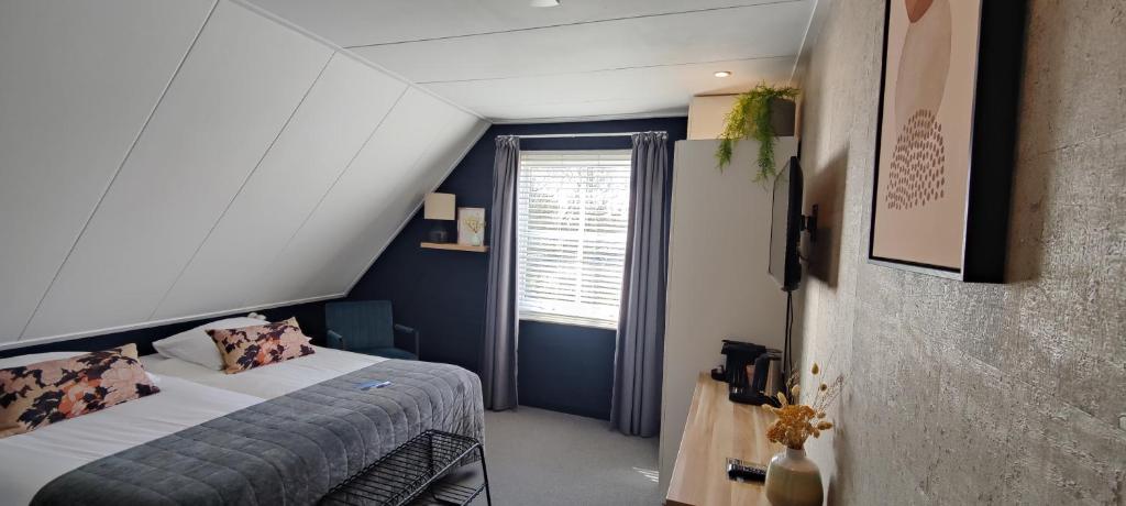 Cette petite chambre comprend un lit et une fenêtre. dans l'établissement Pension Bakema Ameland, à Nes