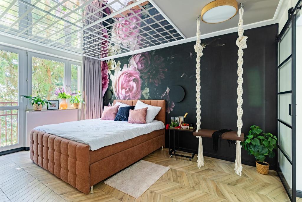 1 dormitorio con cama colgante y mural en la pared en Secret Garden Apartment en Varsovia
