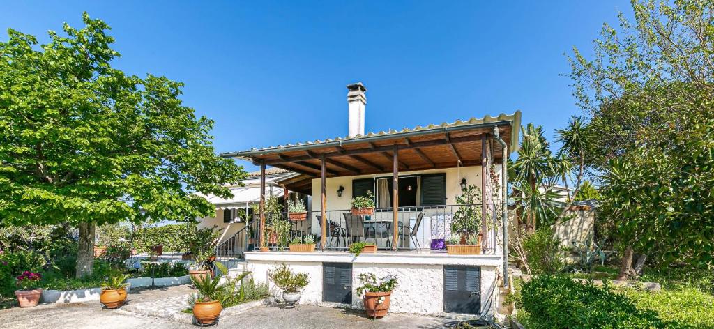 a house with a balcony with potted plants on it at Eutuxia House in Corfu