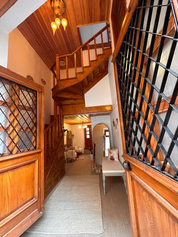 a hallway with a wooden staircase and a wooden door at Hanole Guest House in Ayvalık