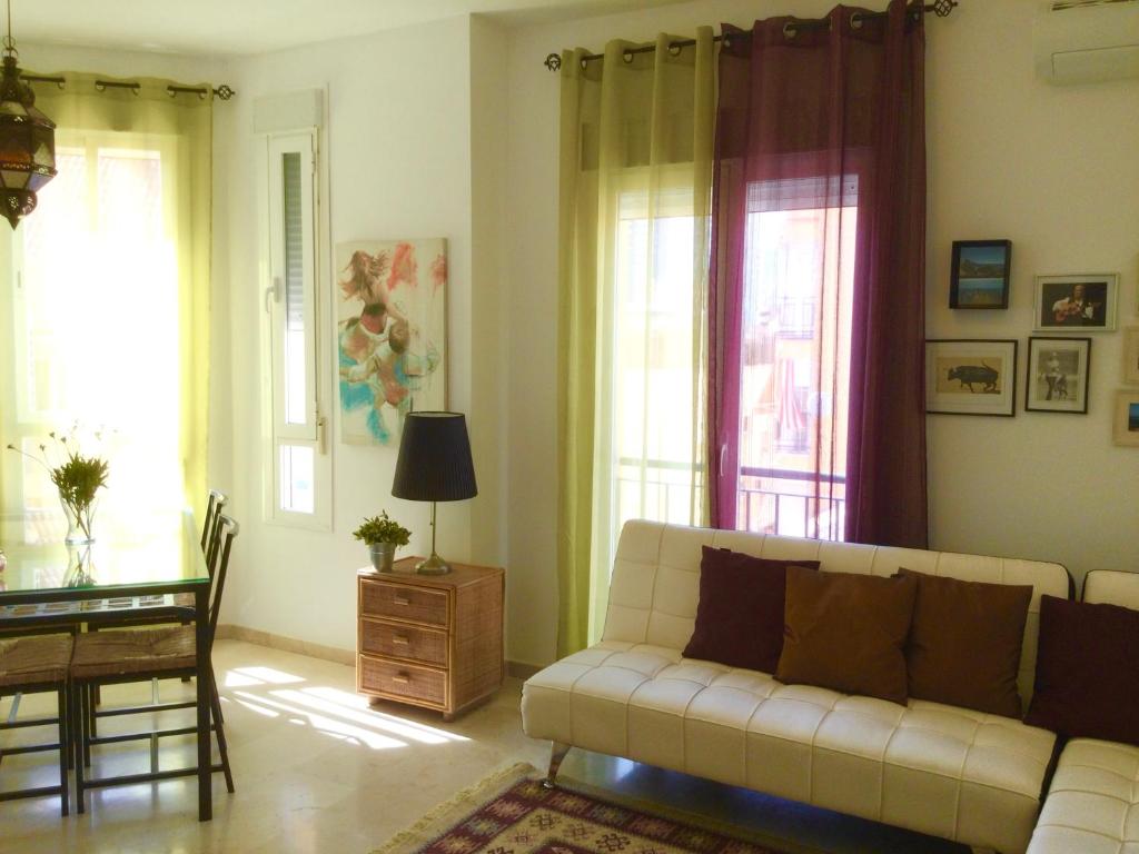 a living room with a couch and a table and windows at Apartamento La vida in Málaga