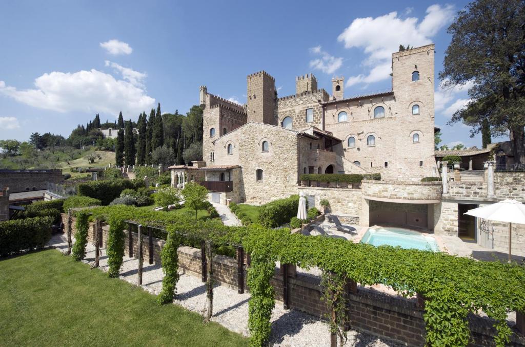 a castle with a swimming pool in front of a yard at Castello Di Monterone in Perugia