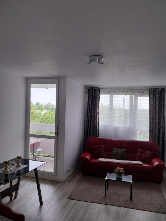 a living room with a red couch and a window at Le lumineux sobre in Melun