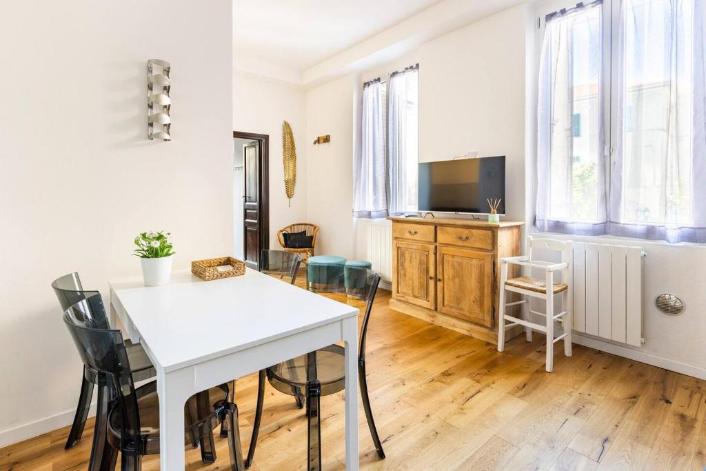 - un salon avec une table et des chaises blanches dans l'établissement La Corte Albenga, à Albenga