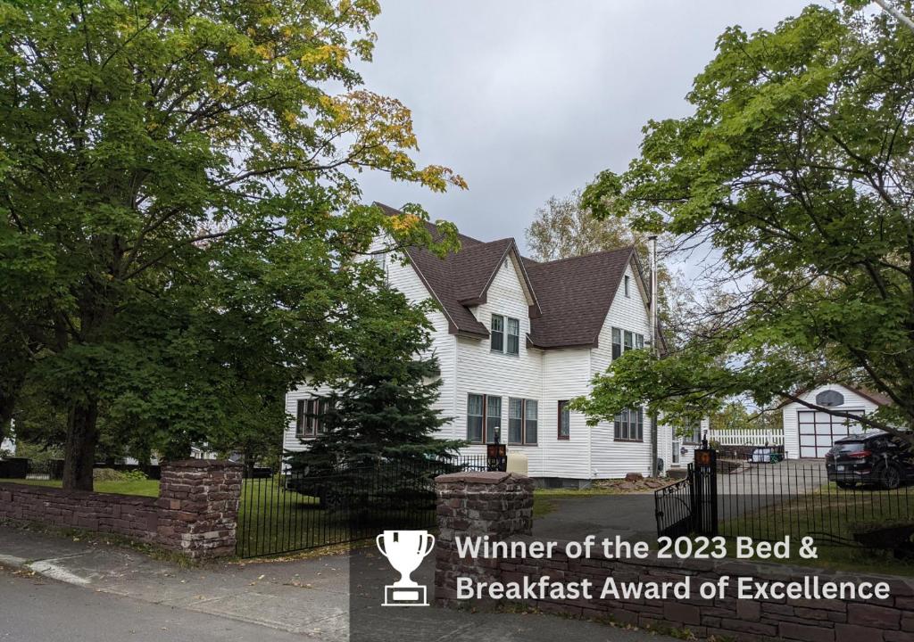 una casa blanca con un cartel delante en Hill Road Manor Bed & Breakfast, en Grand Falls -Windsor