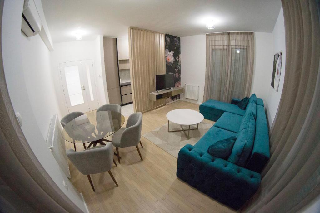 a living room with a blue couch and a table at Apartman David in Trebinje