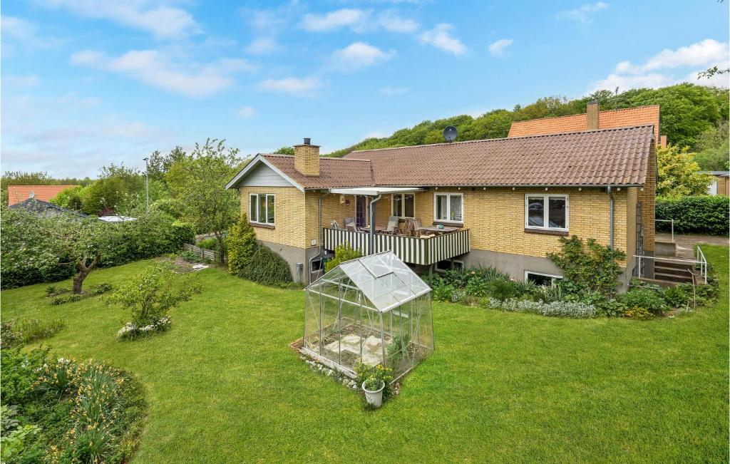 a house with a greenhouse in the yard at Stunning Home In Tranekr With Wifi in Tranekær