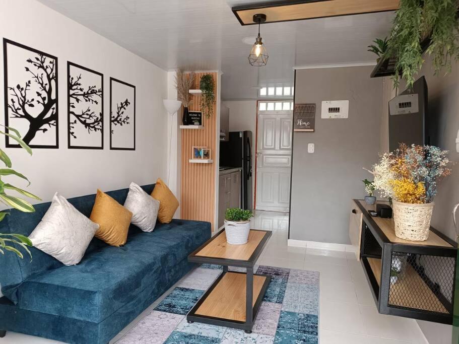 uma sala de estar com um sofá azul e uma mesa em Casa moderna y acogedora. em Salento