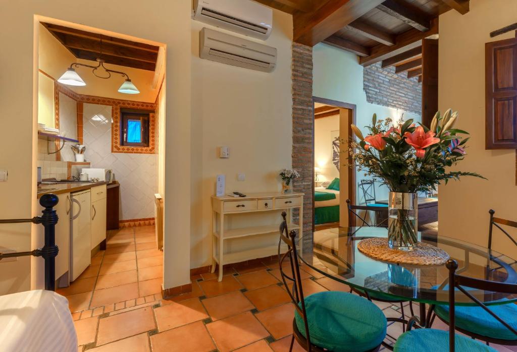 cocina y sala de estar con mesa de cristal y flores en Charminghomesgranada Apartamento Granada Romantica en Granada