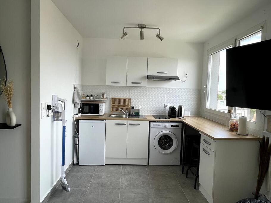 A kitchen or kitchenette at appartement cosy et lumineux