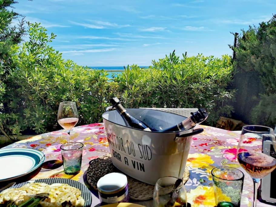 a table with a bucket with a bottle of wine at L'apartment paradise sur mer/80sqm beach front +AC in Menton