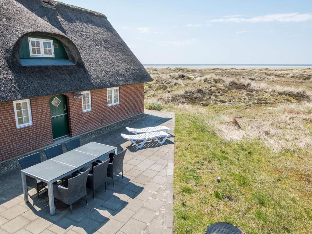 uma casa com uma mesa e cadeiras em frente em Holiday home Fanø CXLIII em Fanø