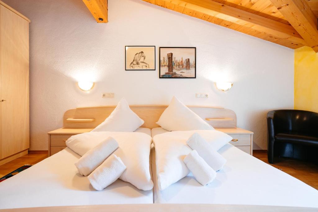 1 dormitorio con cama blanca y almohadas blancas en Appart Taverne, en Mayrhofen