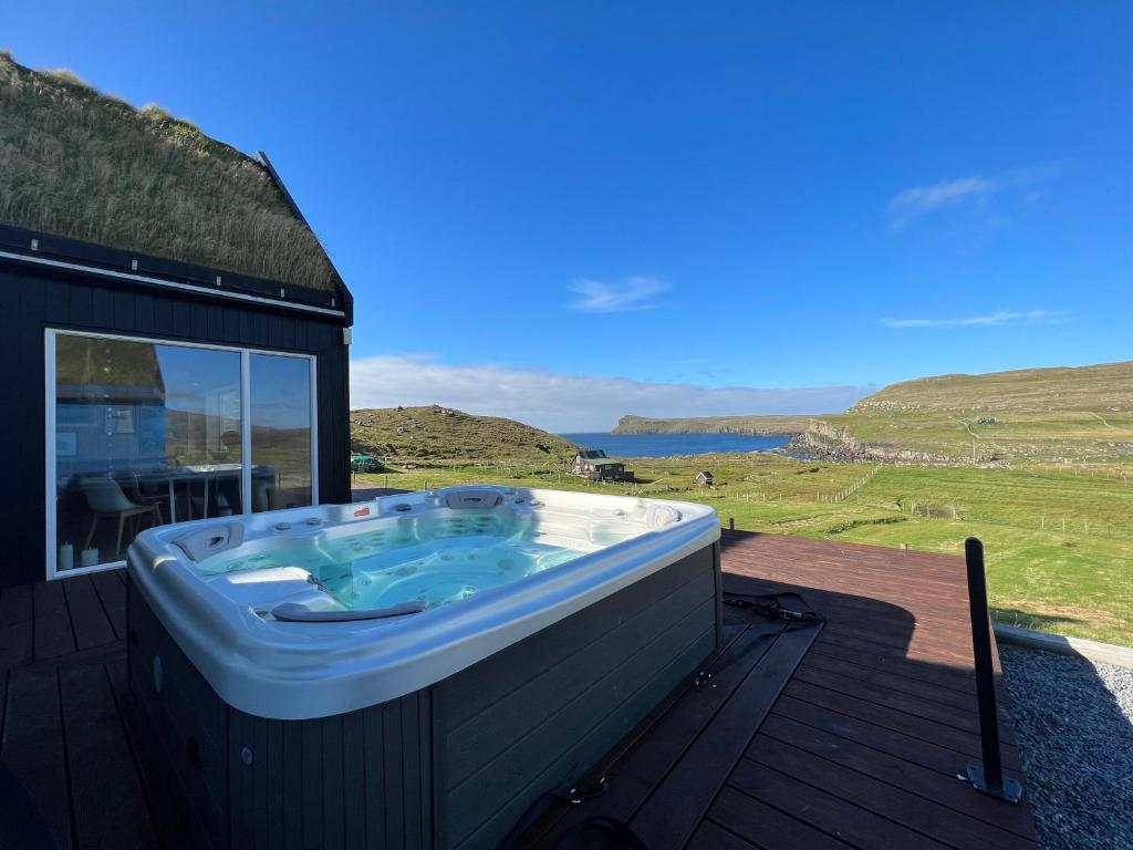 a hot tub on the deck of a house at Luxury cottage - in amazing surroundings in Sandur