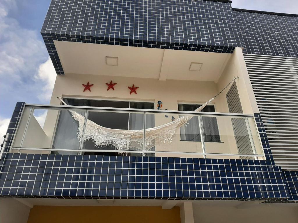 balkon z dwoma gwiazdkami na boku budynku w obiekcie Casa com piscina a 500m da praia w mieście Salinópolis