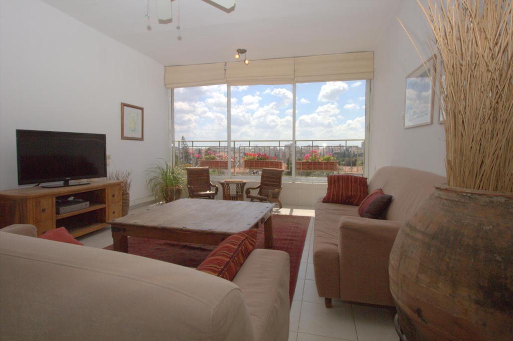 a living room with a couch and a table at Kfar Saba View Apartment in Kfar Saba