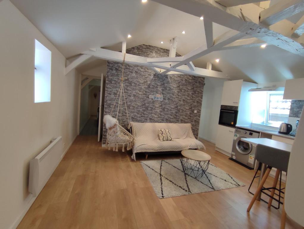 a living room with a hammock hanging from a brick wall at Centre Historique - Charmant T3 - 1h de l Océan in Orthez