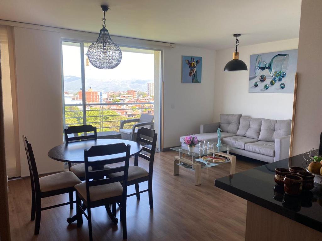 ein Wohnzimmer mit einem Tisch, Stühlen und einem Sofa in der Unterkunft HABITACION DOBLE con baño compartido en apartamento compartido in Bucaramanga