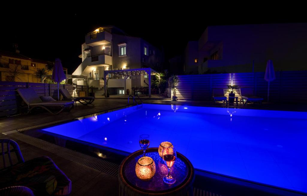 a swimming pool at night with a table next to it at Casa Di Kasapa in Panormos Rethymno