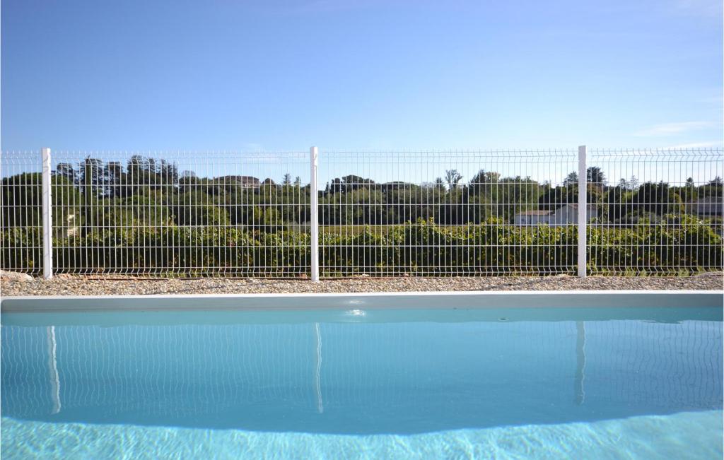 a swimming pool in front of a fence at 2 Bedroom Amazing Home In Saint-ambroix in Saint-Ambroix