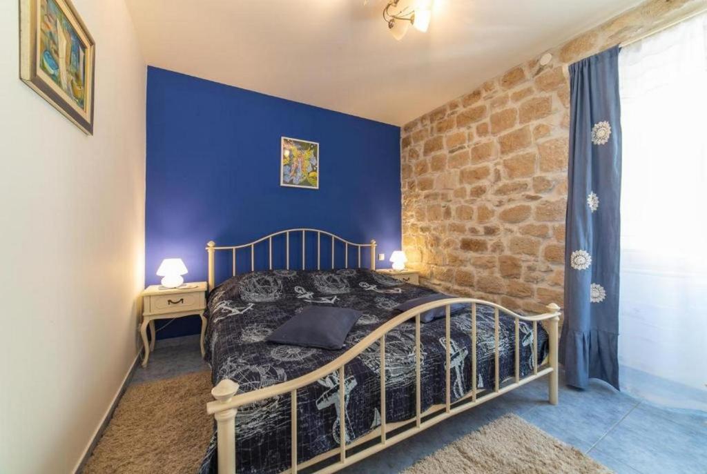 a bedroom with a bed and a blue wall at Apartments by the sea Kastel Novi, Kastela - 21210 in Kaštela