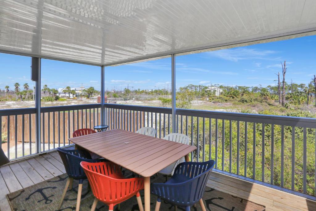 Oak GroveにあるBarrier Dunes 166 - 143 Bay Watch by Pristine Properties Vacation Rentalsのポーチ(木製テーブル、椅子付)