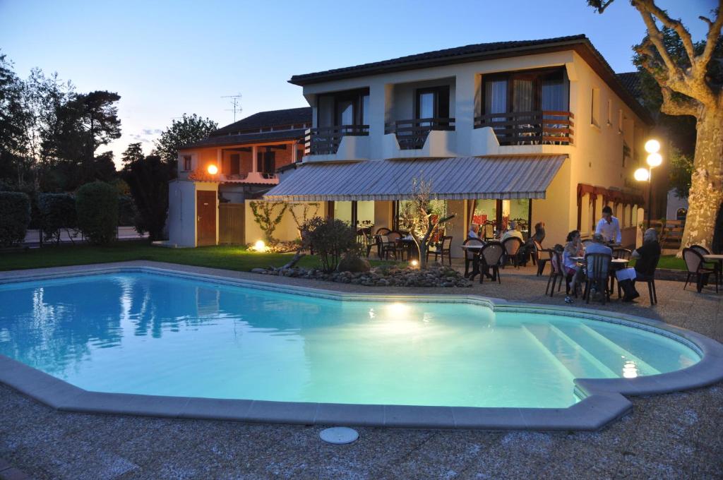 a swimming pool in front of a house at L'Etape Gasconne in Allemans-du-Dropt