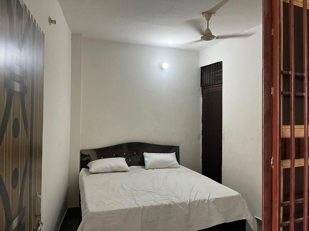 een slaapkamer met een bed en een plafondventilator bij OYO Home R K Oyo Hotel in Noida