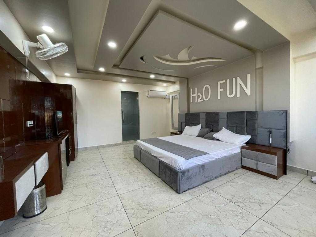 een slaapkamer met een bed met een halofin-bord aan de muur bij OYO Flagship 81235 Ho Fun Park in Ambala