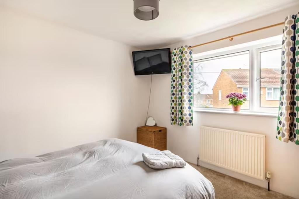 Schlafzimmer mit einem Bett, einem TV und einem Fenster in der Unterkunft Double Room, Large TV, With Great Transport Links in Bolton