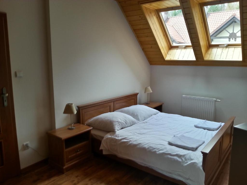 1 dormitorio con 1 cama y 2 ventanas en Belweder Apartamenty i Pokoje, en Wisła