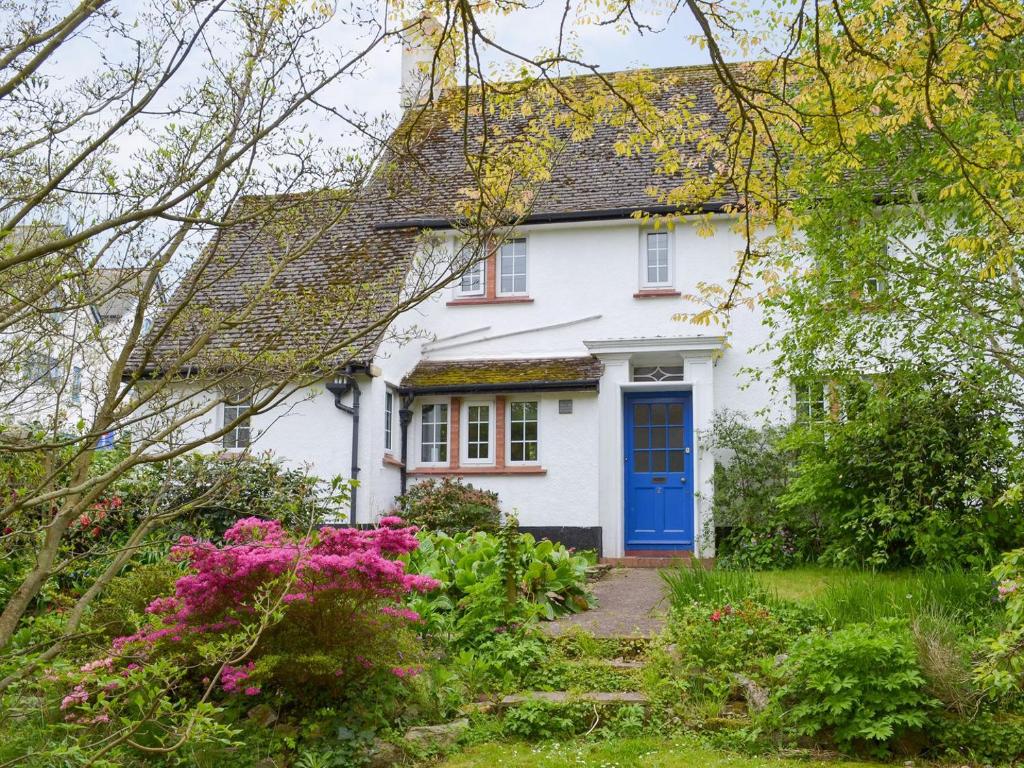 a white house with a blue door at Green Hedges in Budleigh Salterton